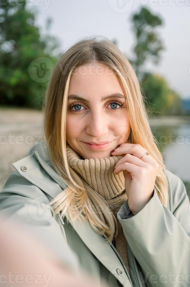 Smiling woman in coat looking at camera photo