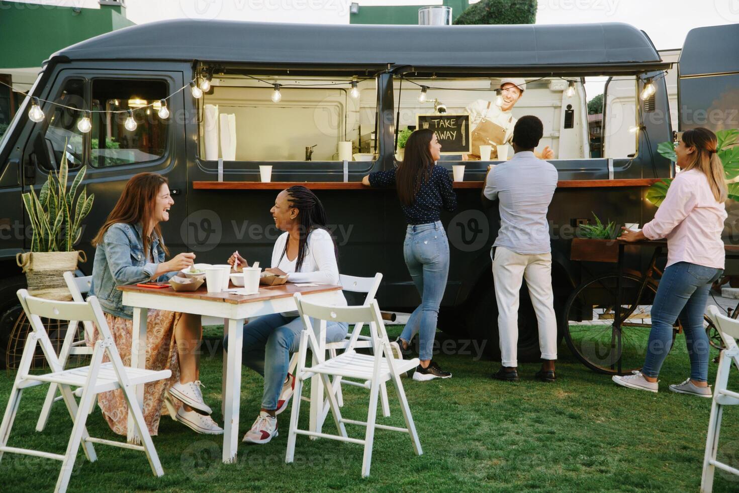 Food truck customers chatting with each other and vendor photo