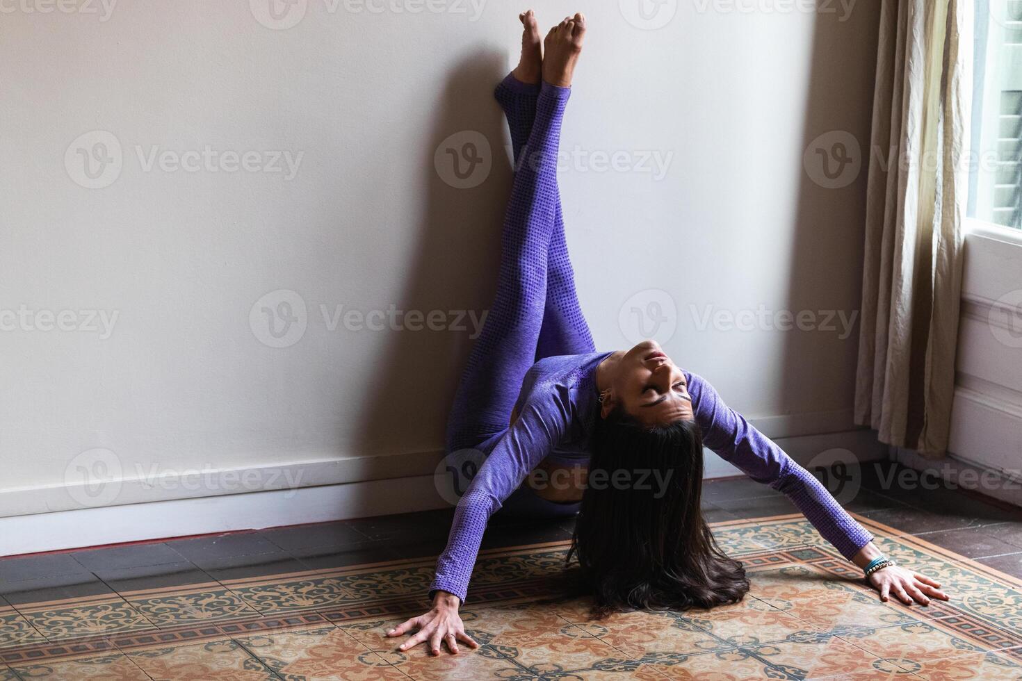 Peaceful young ethnic woman with closed eyes practicing yoga at home photo