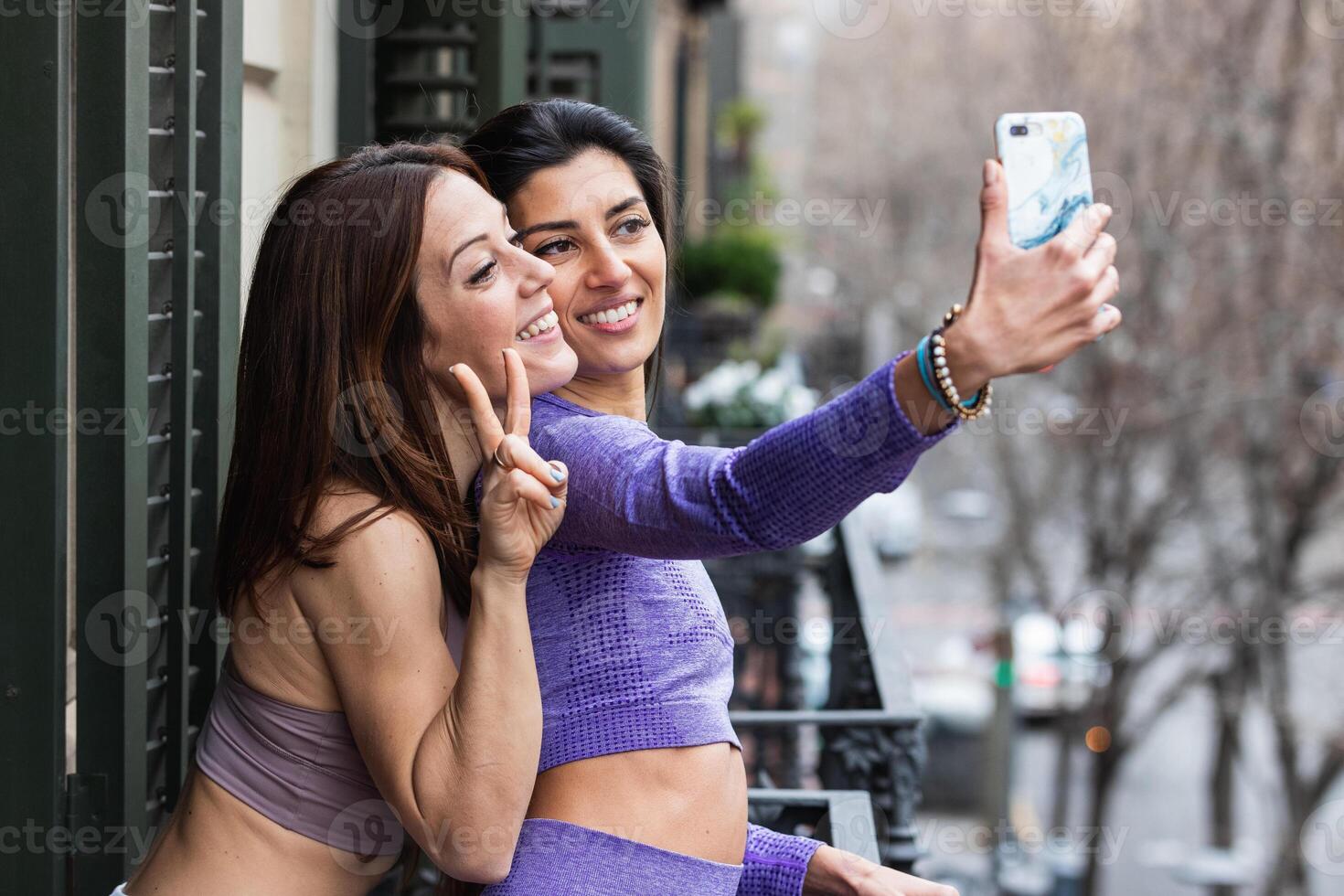 Happy friends taking selfie on balcony photo