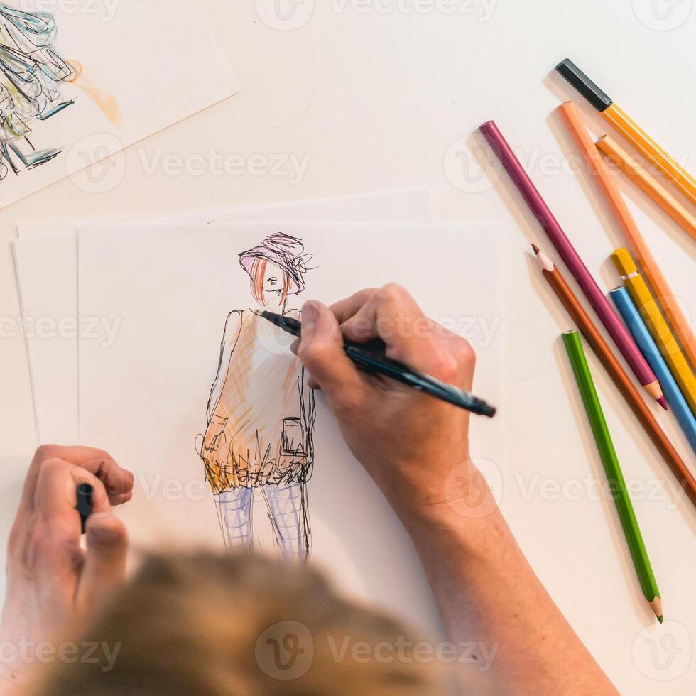 Top view of a fashion designer drawing a fashion sketch. photo