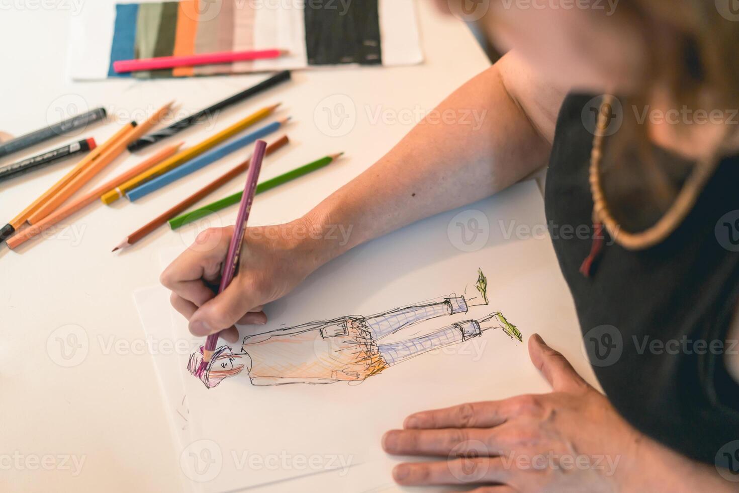 Fashion designer drawing a fashion sketch with colorful pencils photo