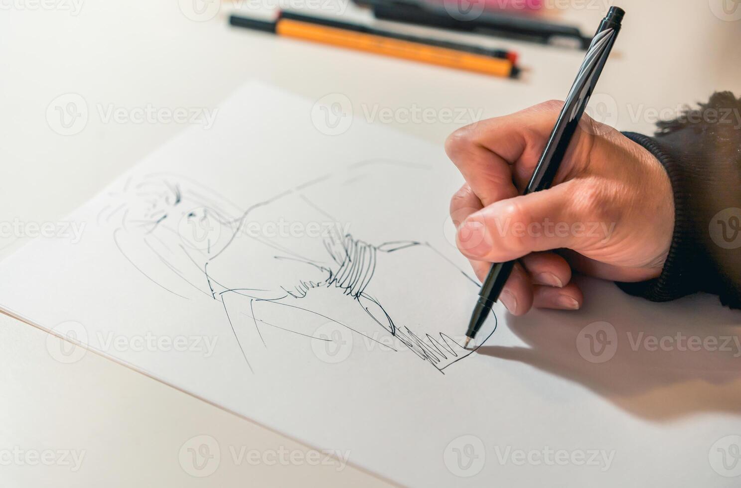 Close-up of a femaile desinger drawing with a pencil. photo