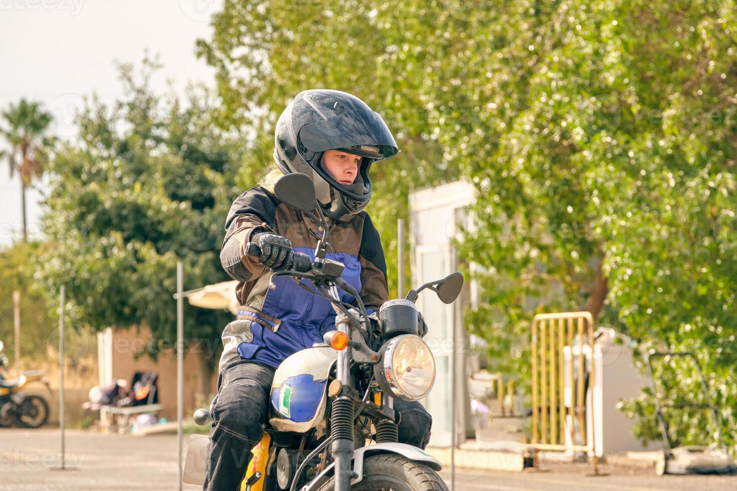 Serious woman riding motorbike during lesson photo