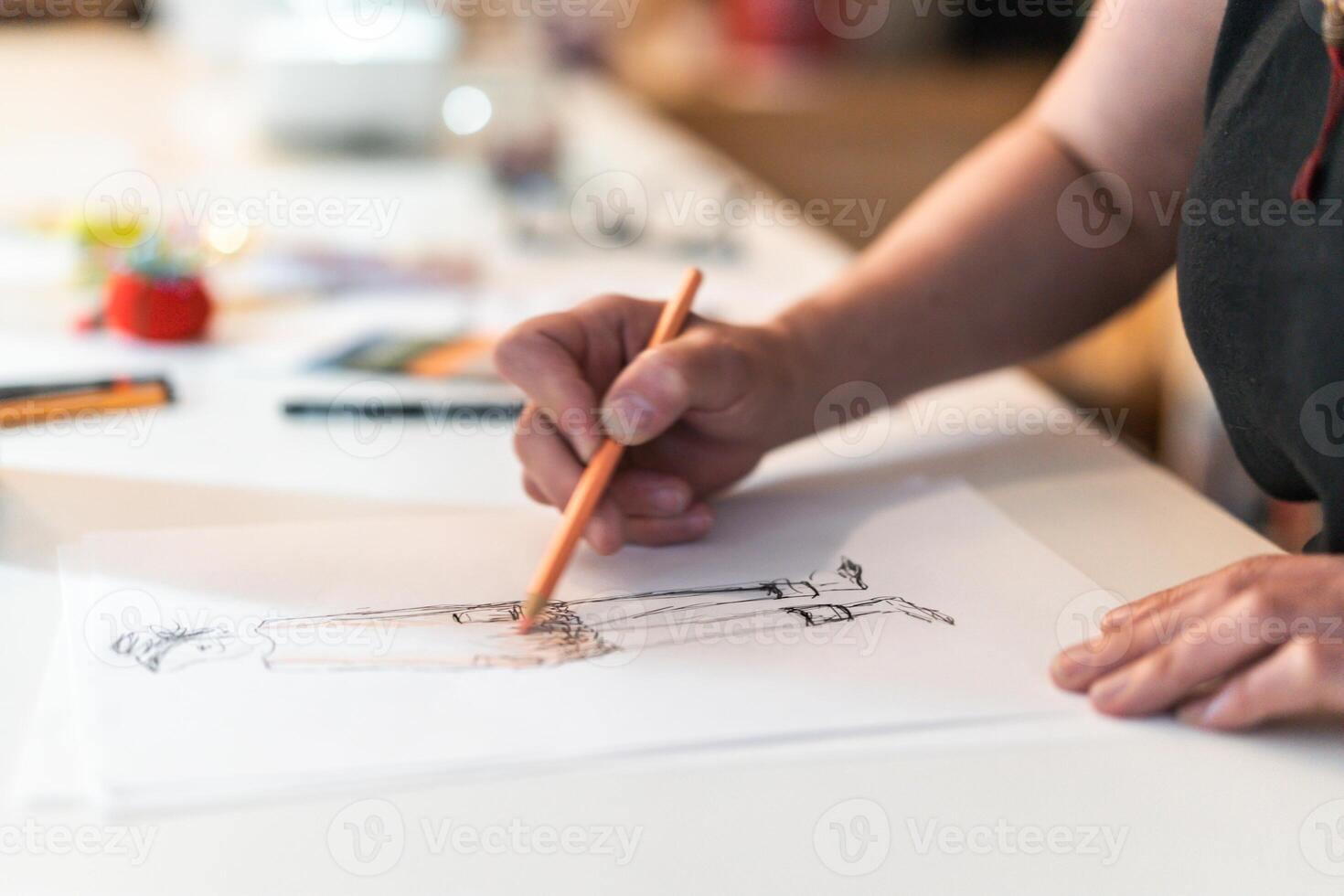 Close-up of a fashion designer drawing a fashion sketch. photo
