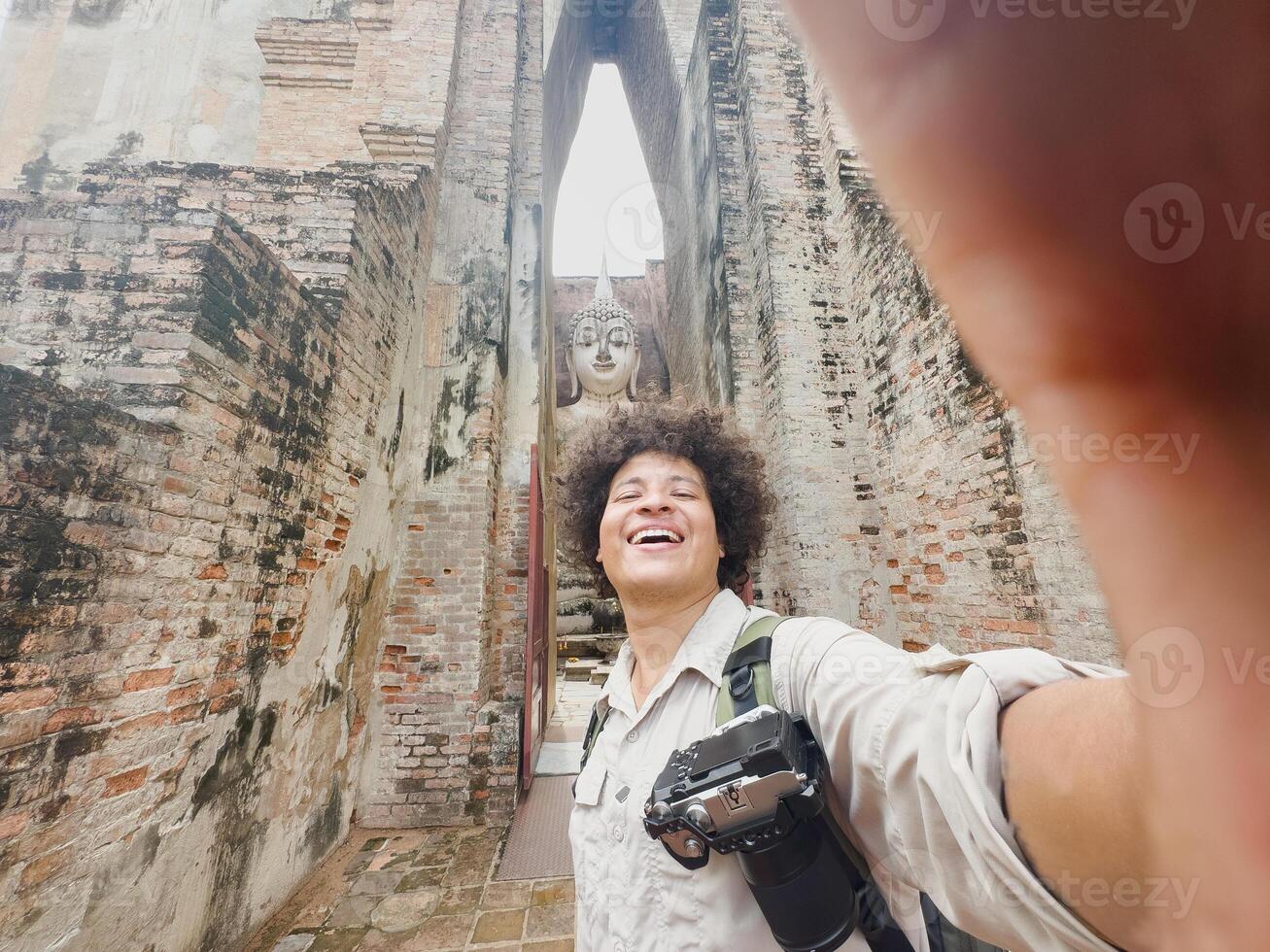Joyful selfie capturing a traveler with smartphone and Buddha statue, Joyful selfie capturing a traveler with smartphone and Buddha statue photo
