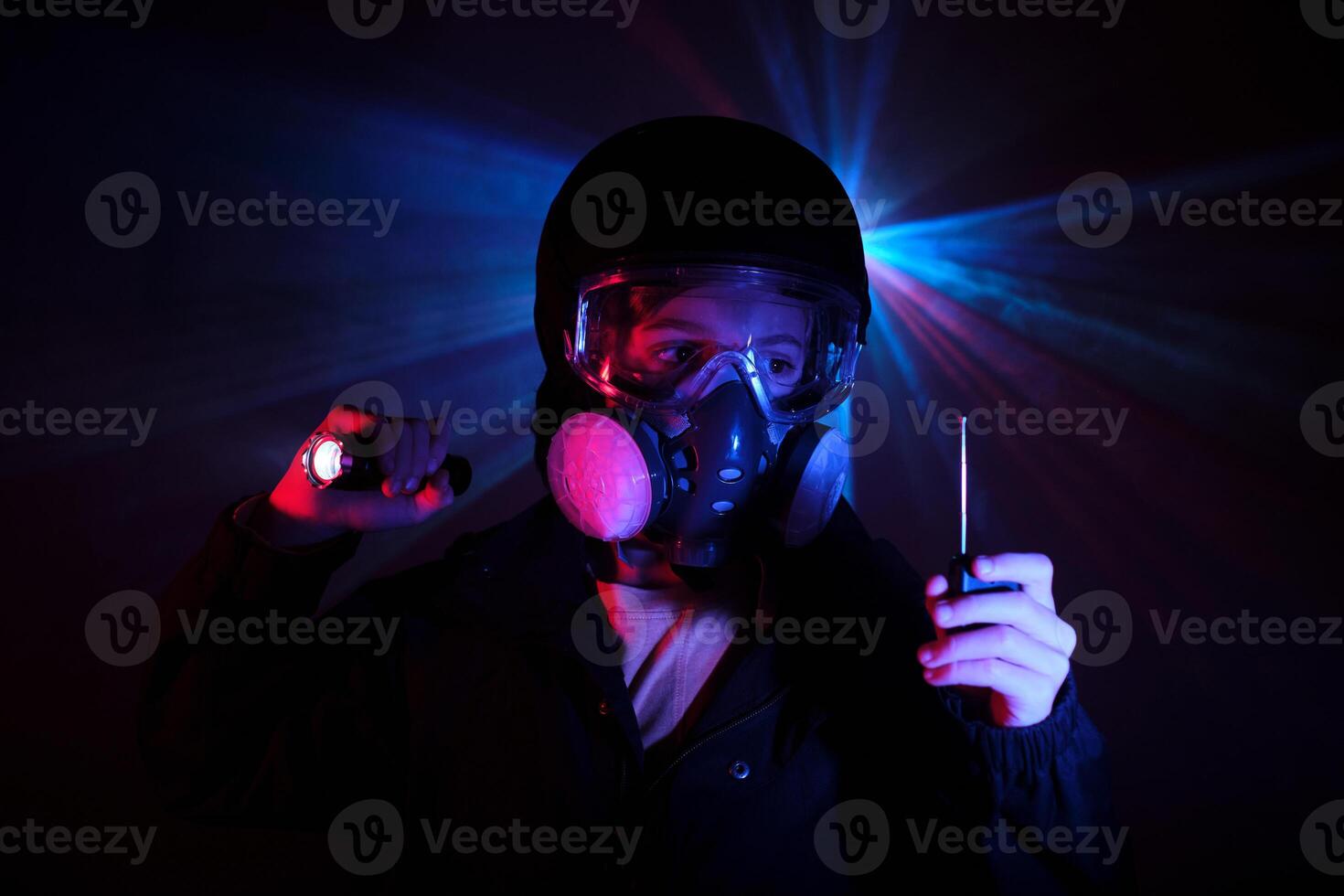 Boy with walkie talkie and in mask in dark studio photo