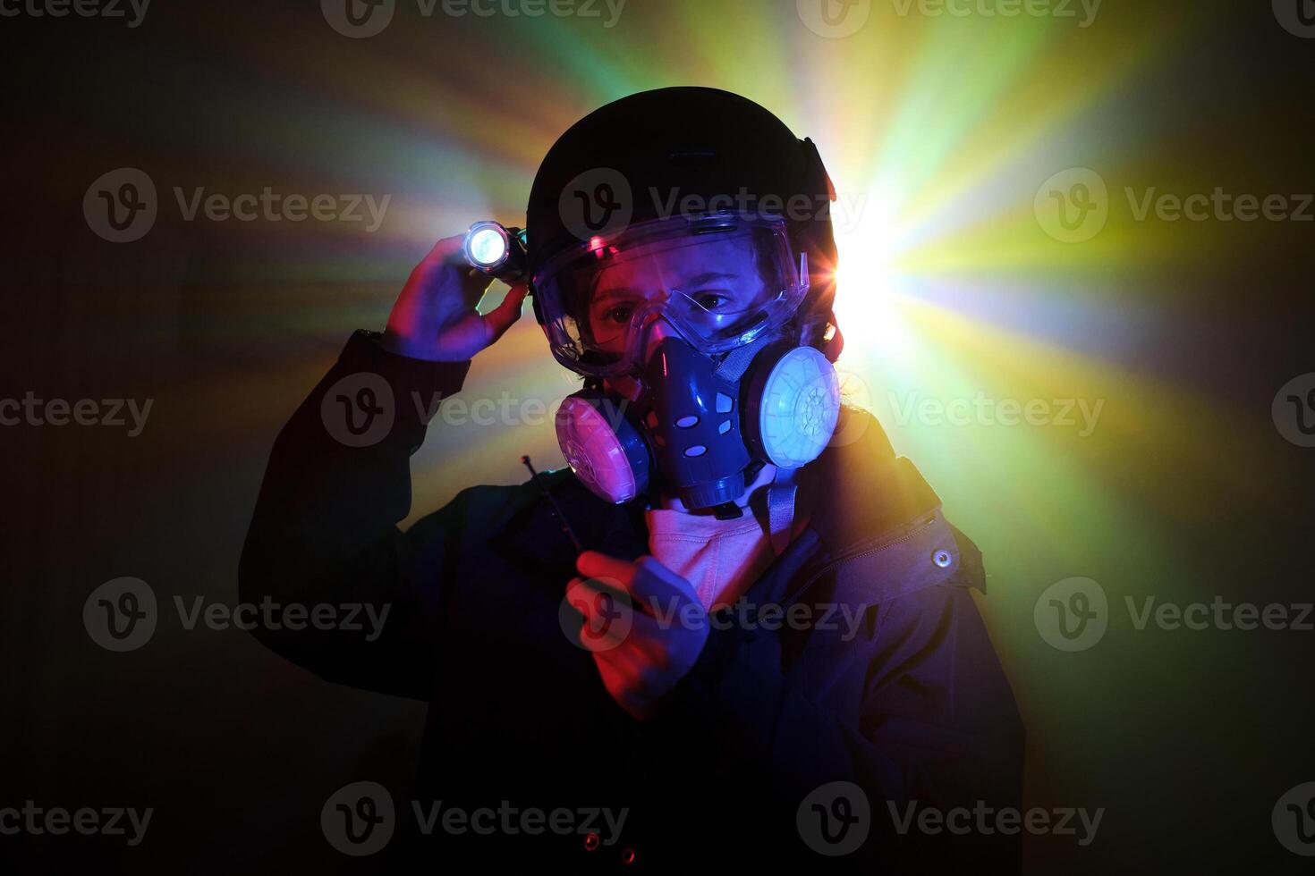Thief in respirator with flashlight in darkness photo