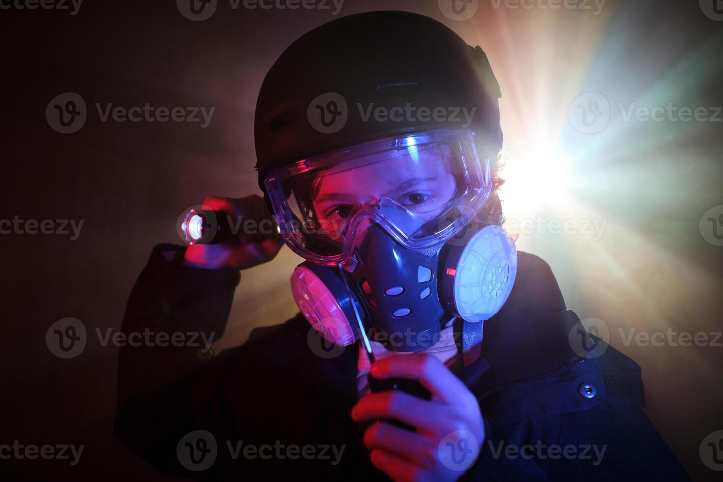 Boy in respirator with walkie talkie in dark studio photo