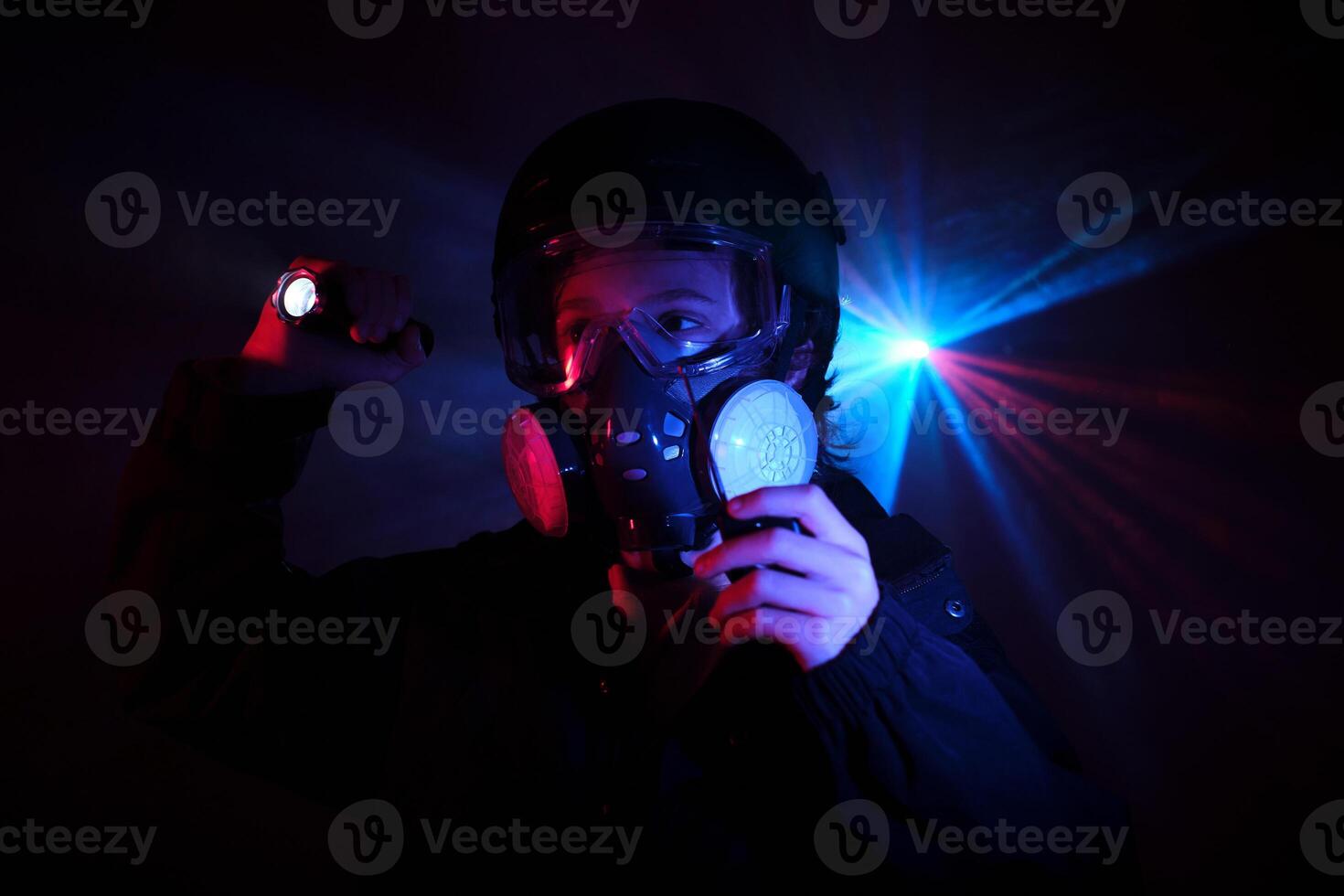 Thief in respirator in dark studio with neon lights photo