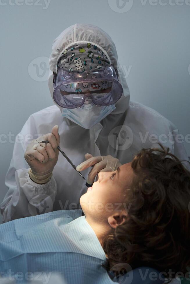 Unrecognizable dentist examining patient in hospital photo
