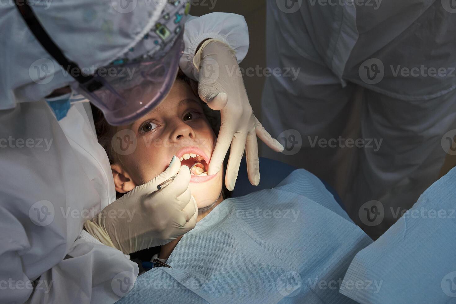Child having teeth examined by dentist photo