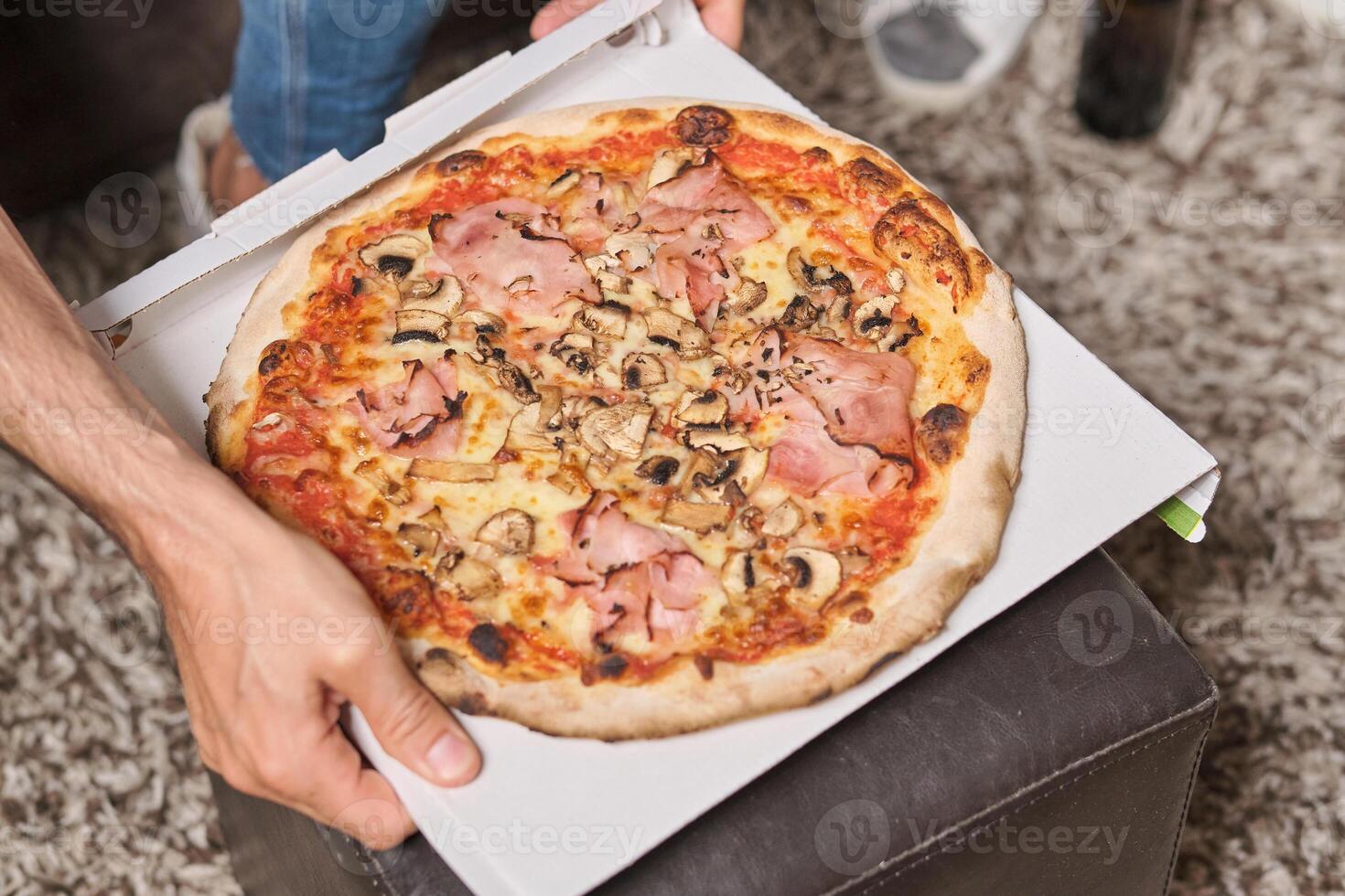 Crop man with takeaway pizza on table photo