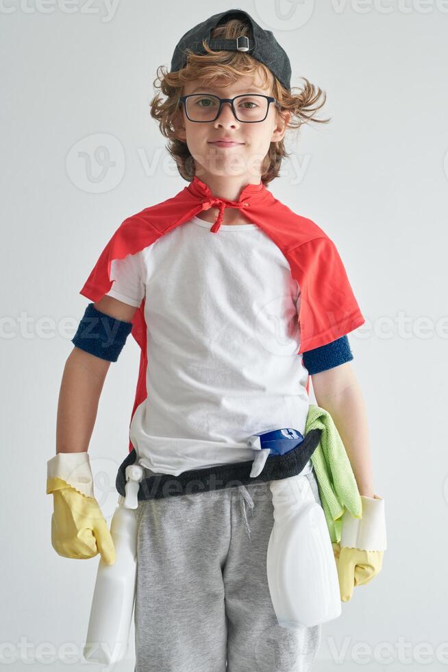 Positive boy wearing costume with detergents standing near studi photo