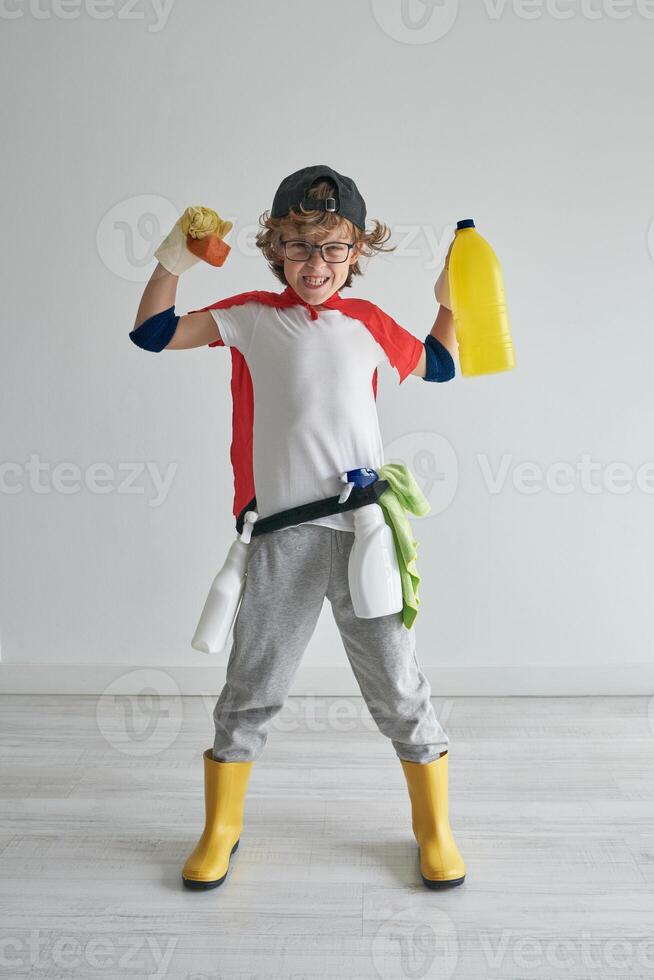 Cheerful boy holding soap and yellow bottle in hands in studio photo