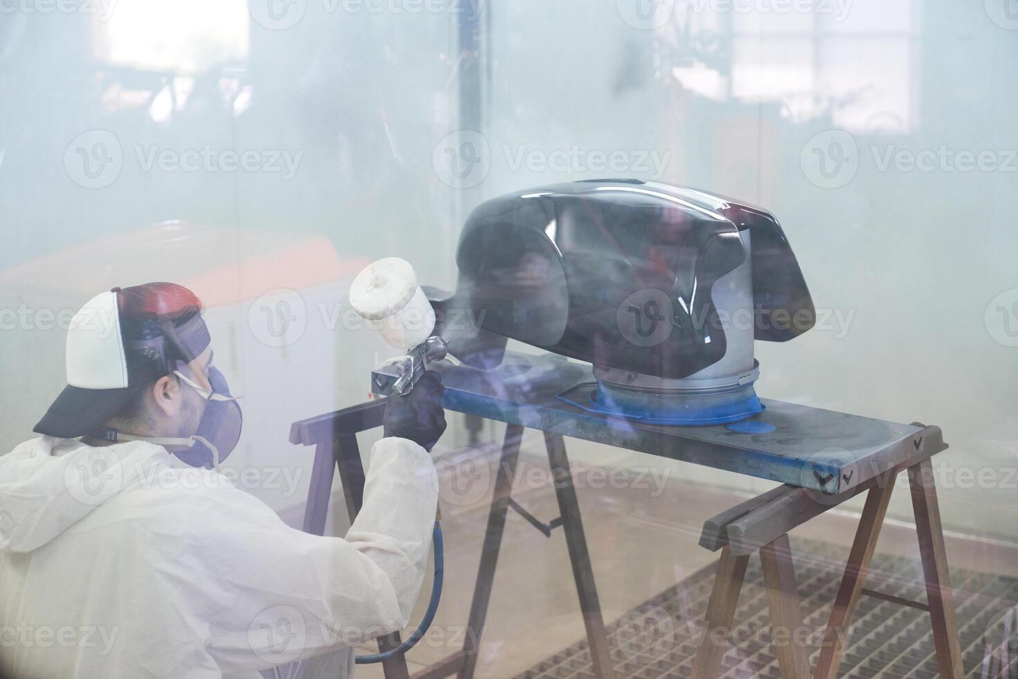 Unrecognizable male mechanic painting motorbike tank photo