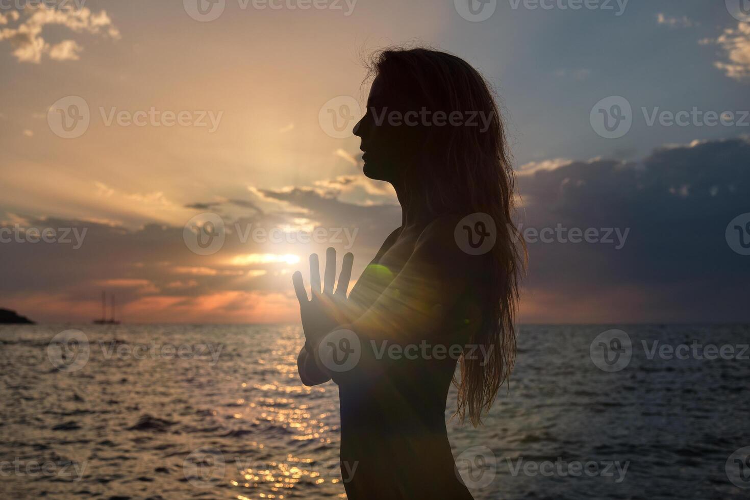Unrecognizable woman practicing yoga in Mountain pose near sea i photo