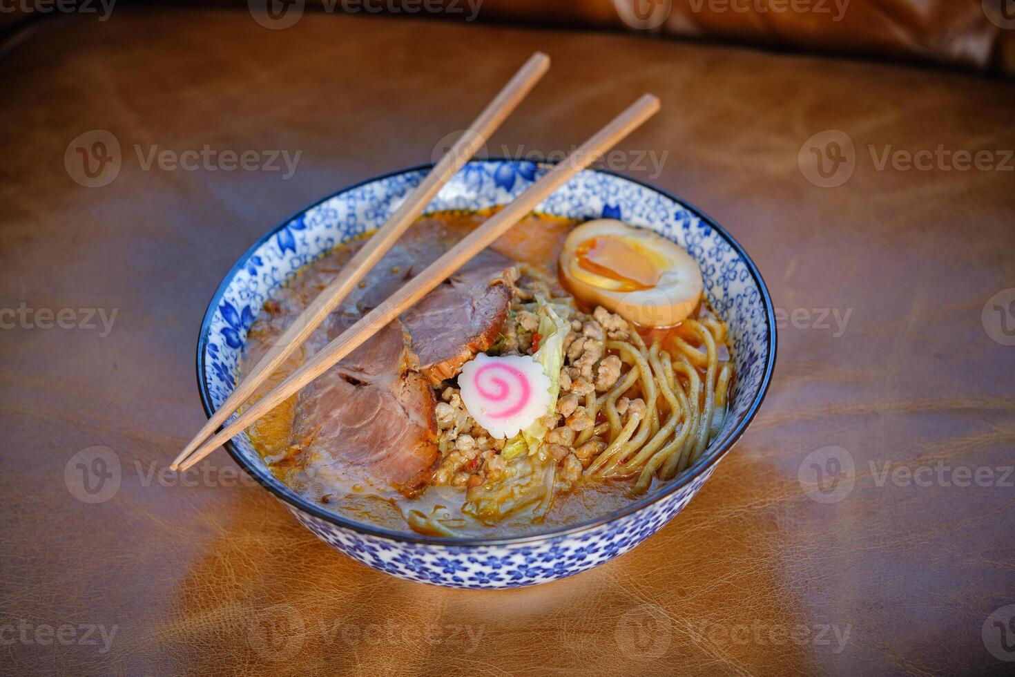Asian noodle soup with chopsticks in bowl photo