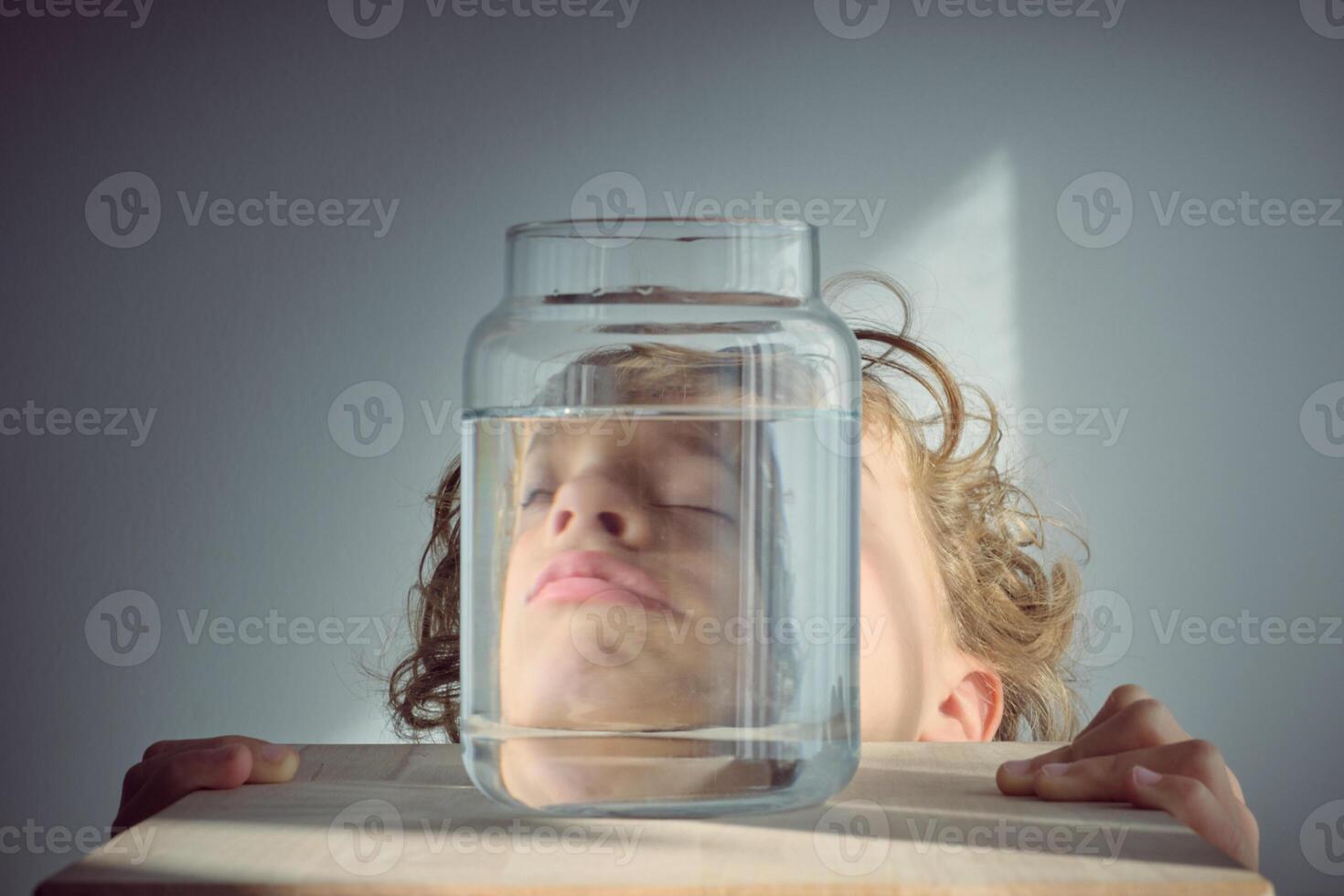 Napping boy near glass jar of water photo