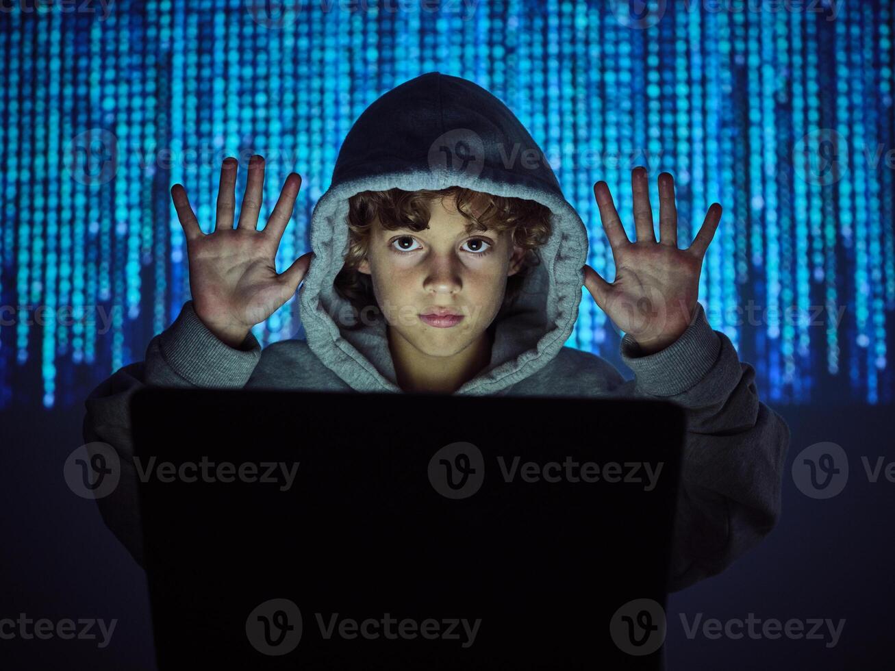 Programmer boy with hands up at laptop photo