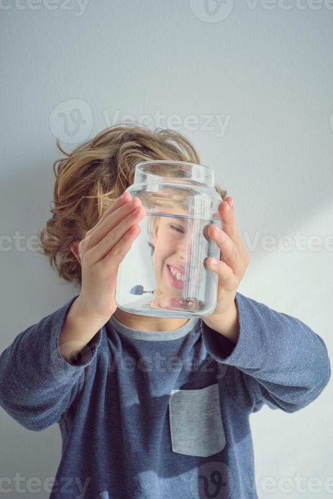 Smiling boy with glass jar of water photo