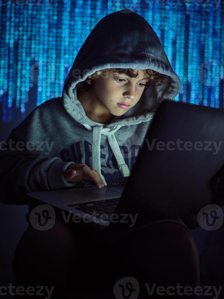 Serious boy using laptop on binary code background photo