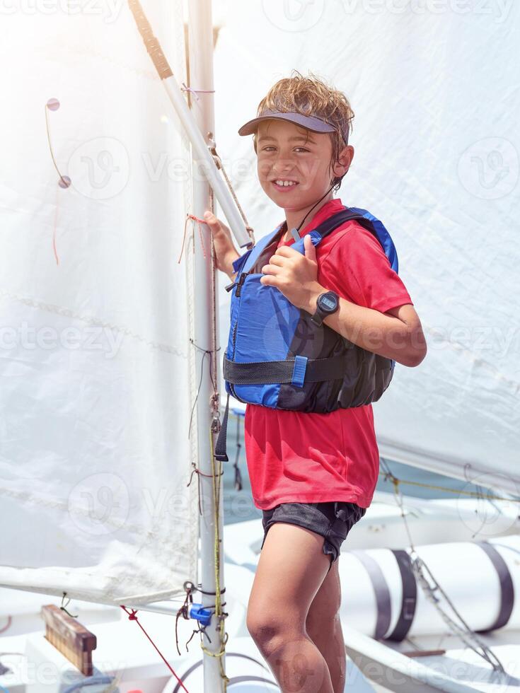Smiling boy standing on sailboat photo