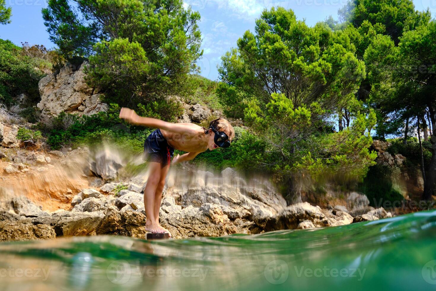 Unrecognizable boy diving into water photo