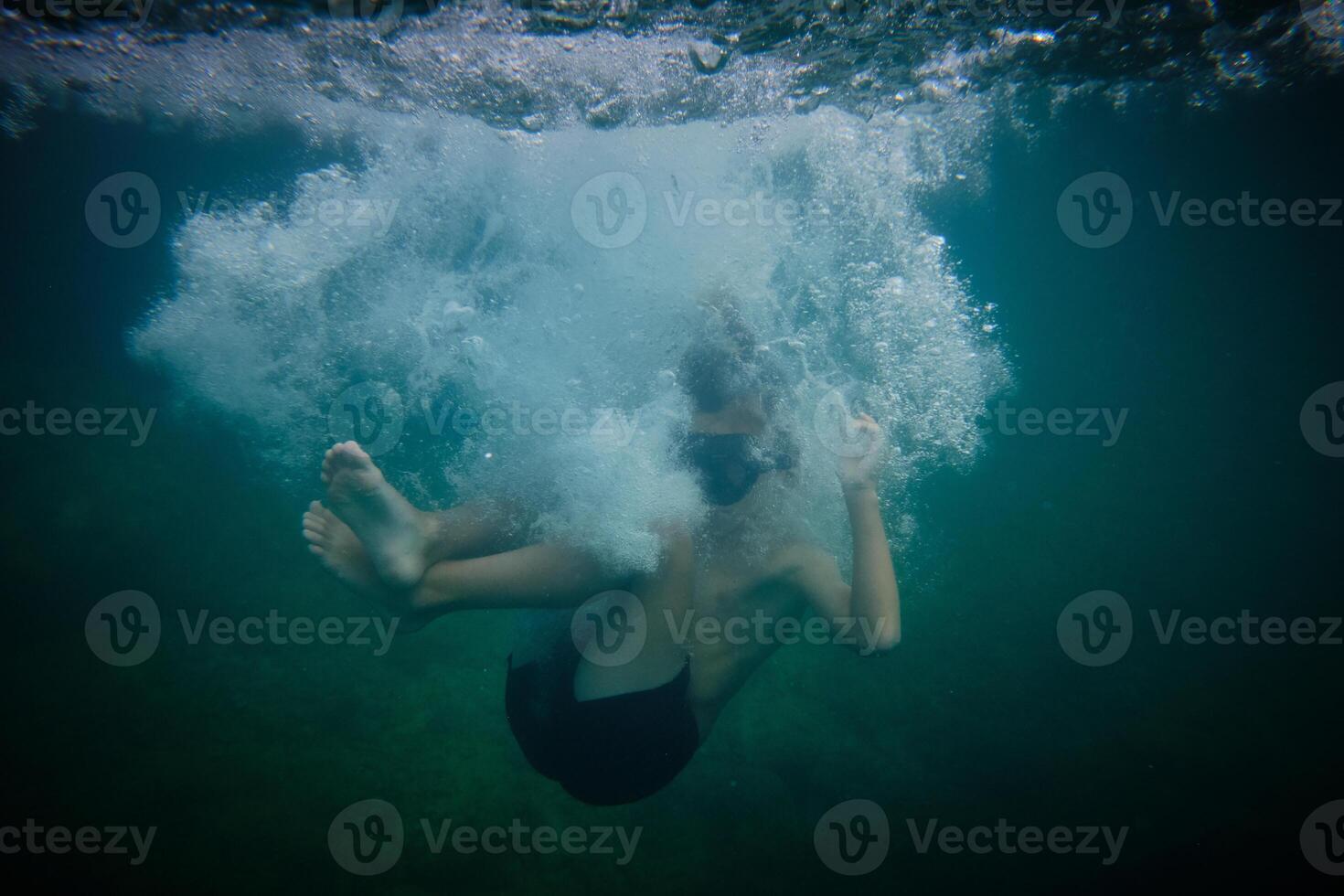 Boy underwater in clear sea photo
