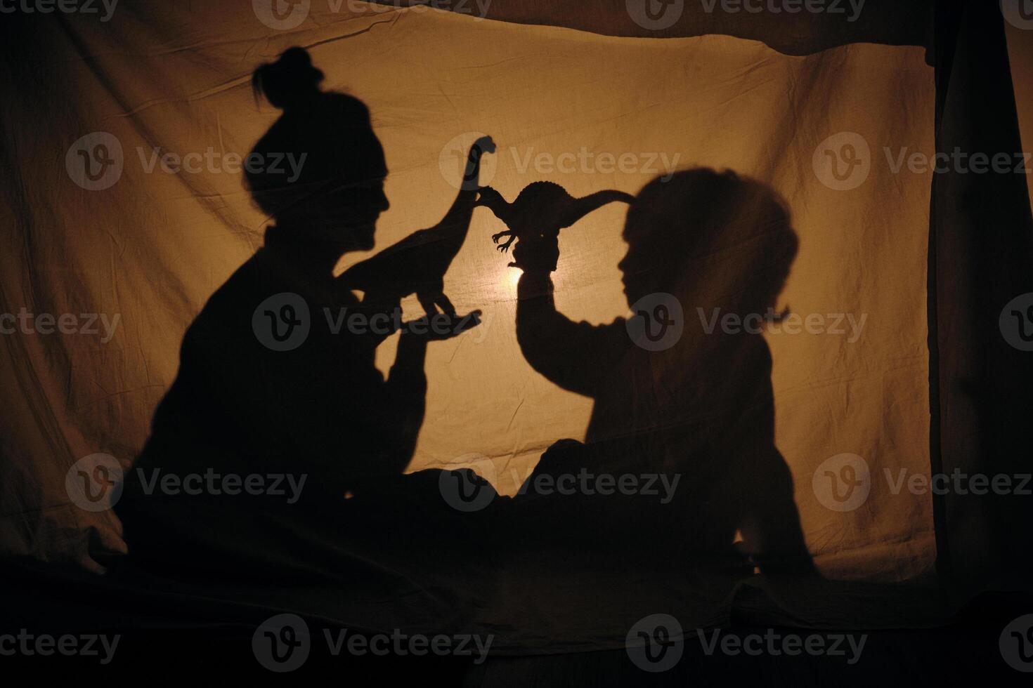 Silhouette of woman and boy playing in shadow theater photo