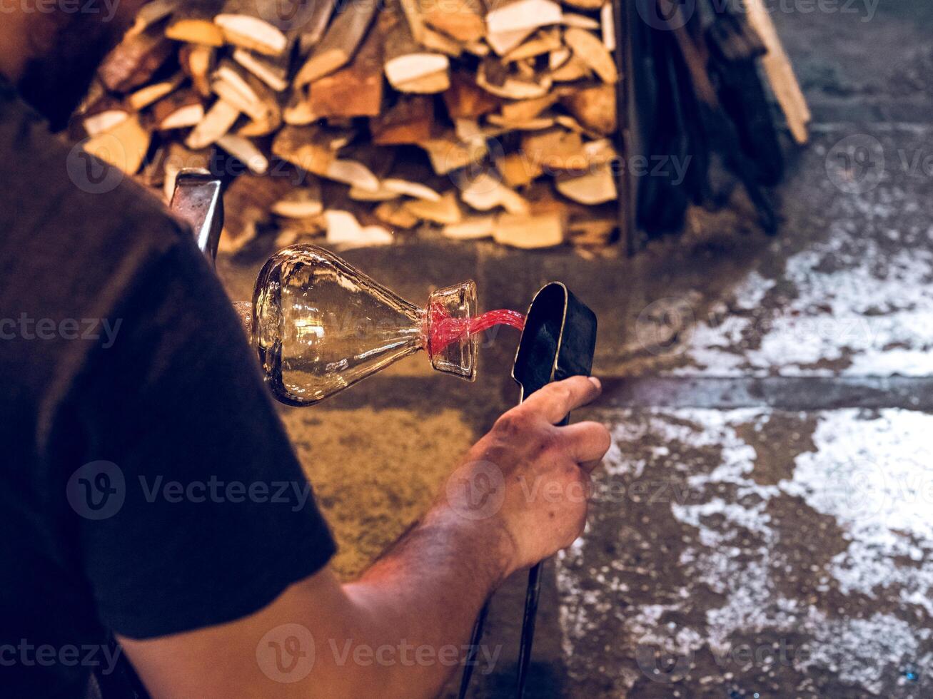 Anonymous glassblower making vase in workshop photo