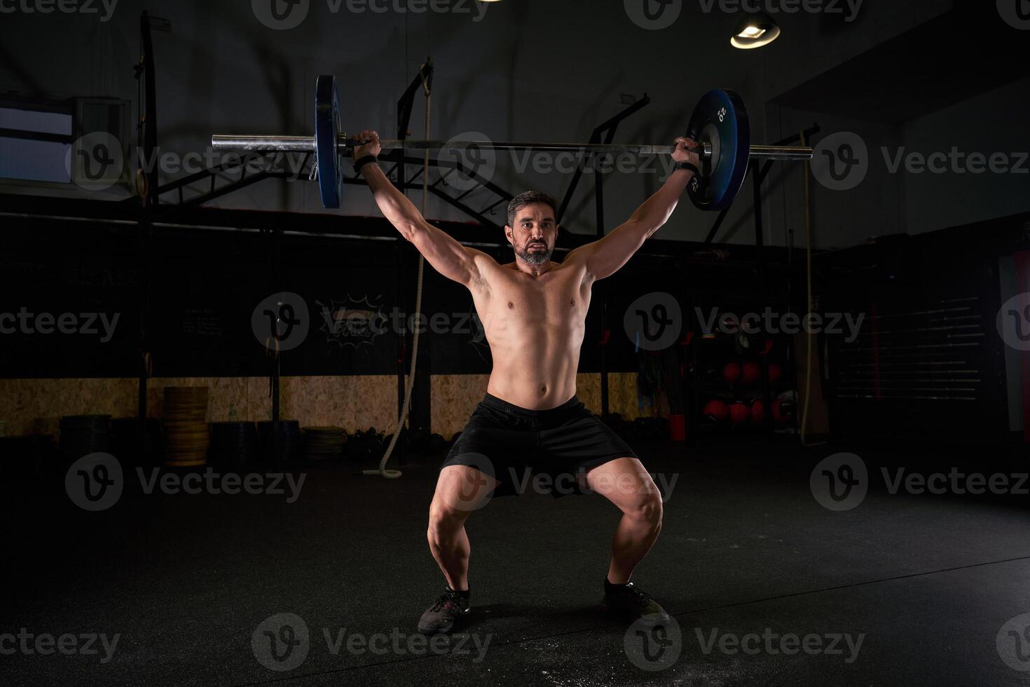 Man with raised hands with barbell while doing weightlifting exe photo