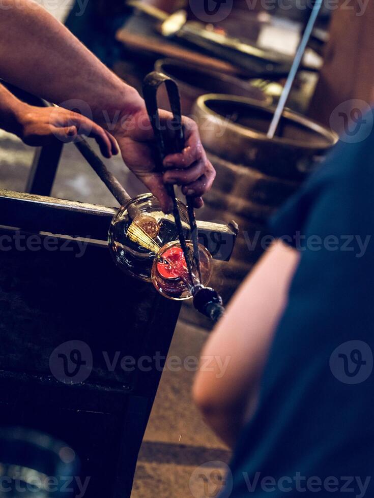 Anonymous masters making glass utensil in factory photo