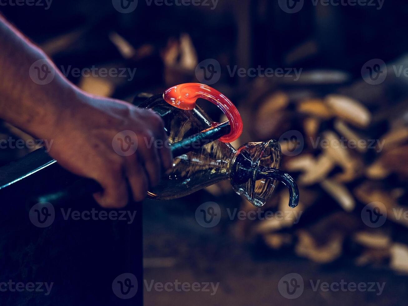 Anonymous craftsman making glass carafe in factory photo