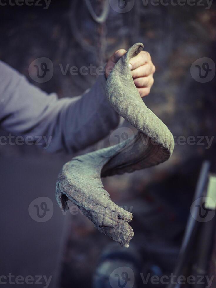 Crop male blacksmith showing metal in forge photo