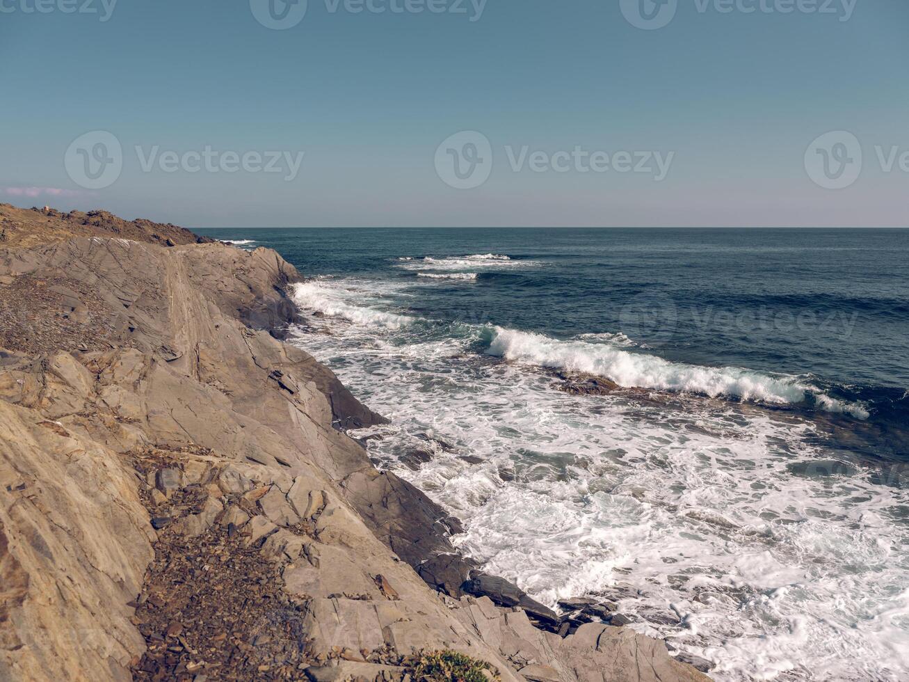 Wavy ocean washing rocky formations photo