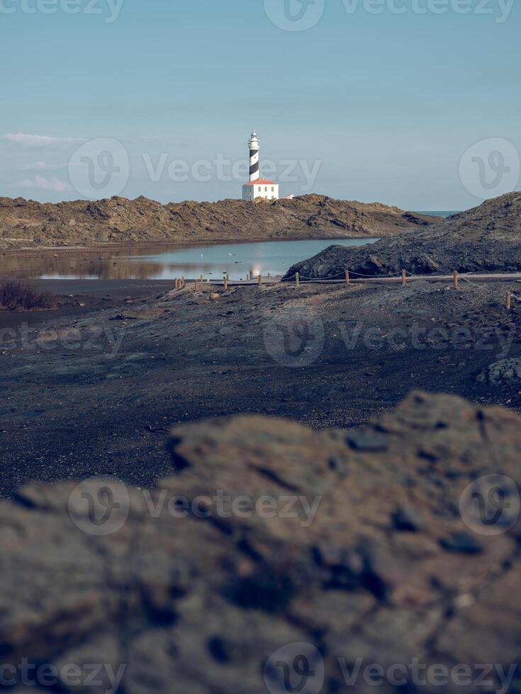 Lake and lighthouse in rocky terrain photo