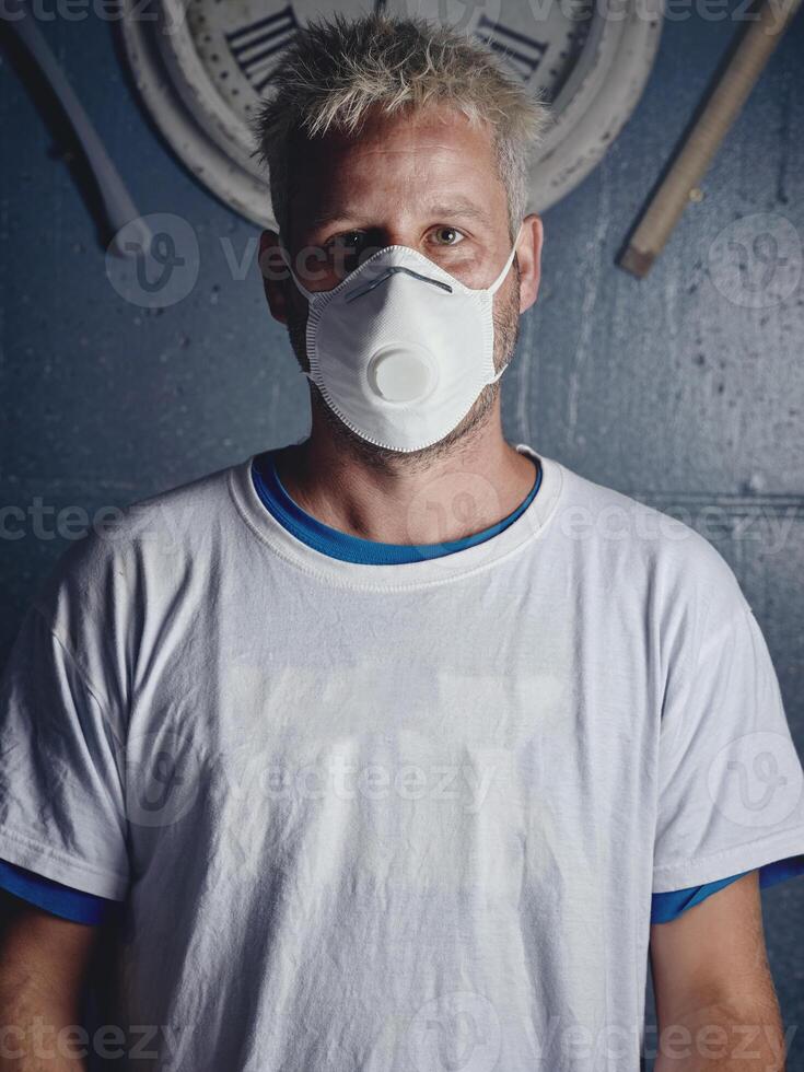 Blond surfboard maker with tattoos in mask photo
