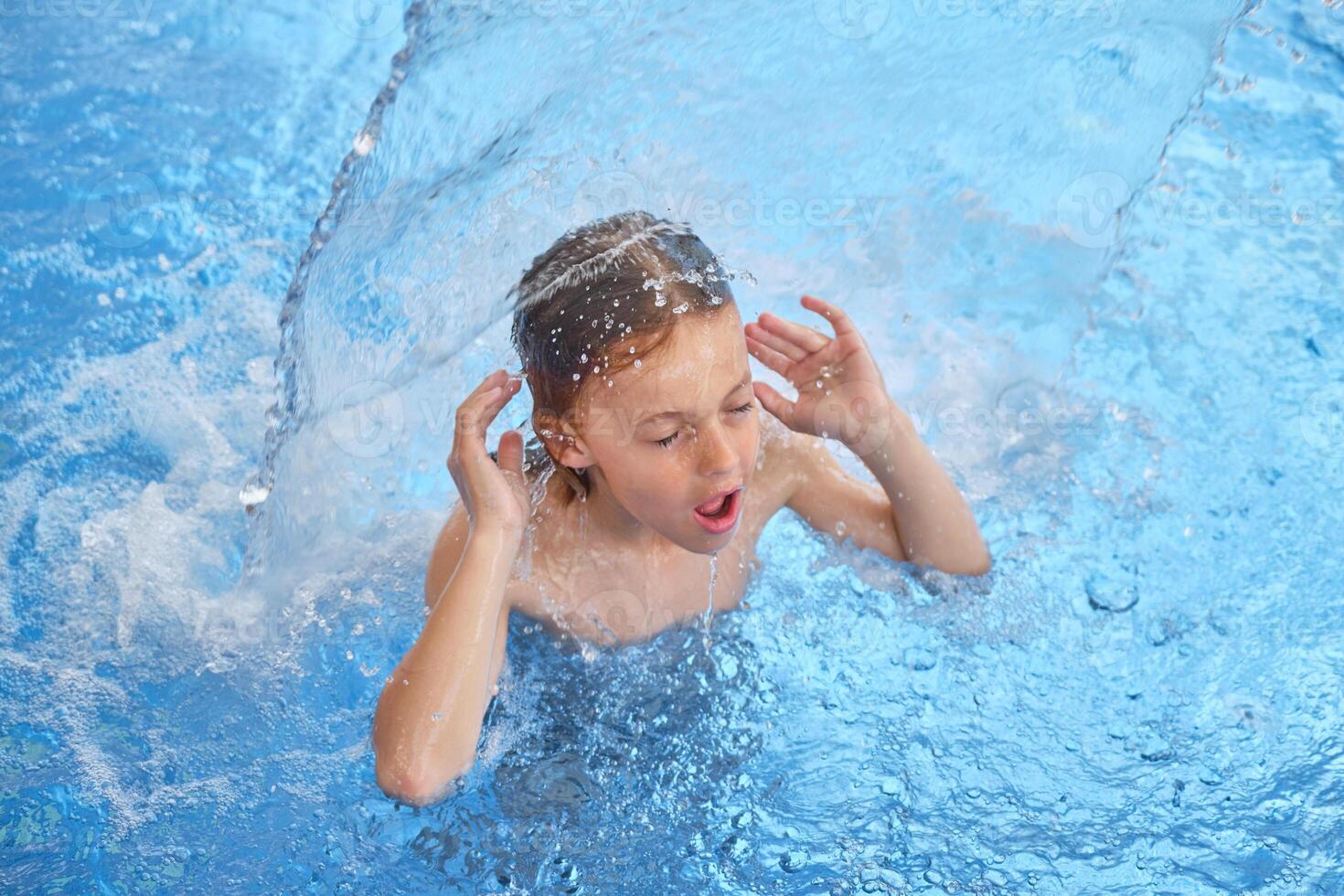 Boy with opened mouth and closed eyes in swimming pool photo