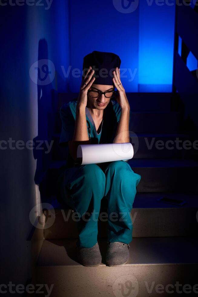 Concentrated female medic reading documents on stairs photo
