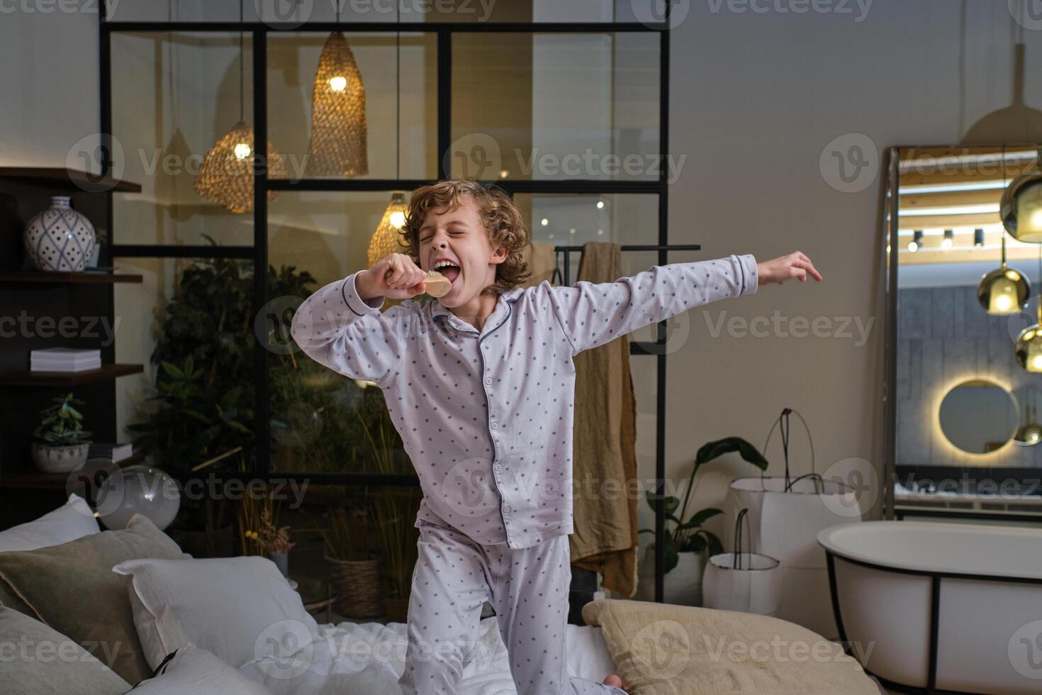 Carefree boy singing in bedroom photo