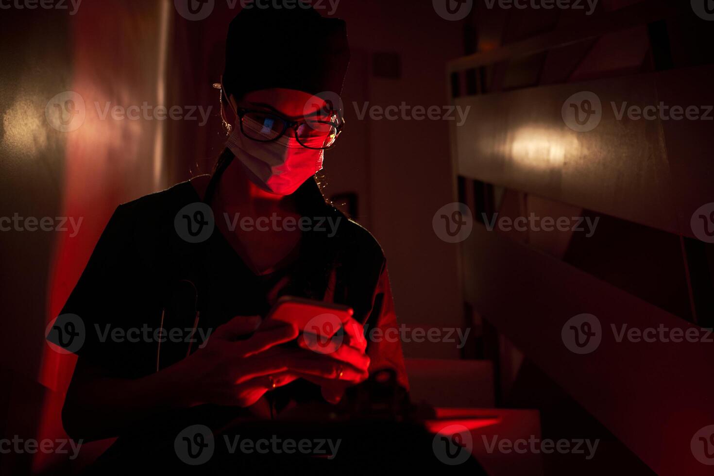 Serious medic browsing cellphone on staircase photo
