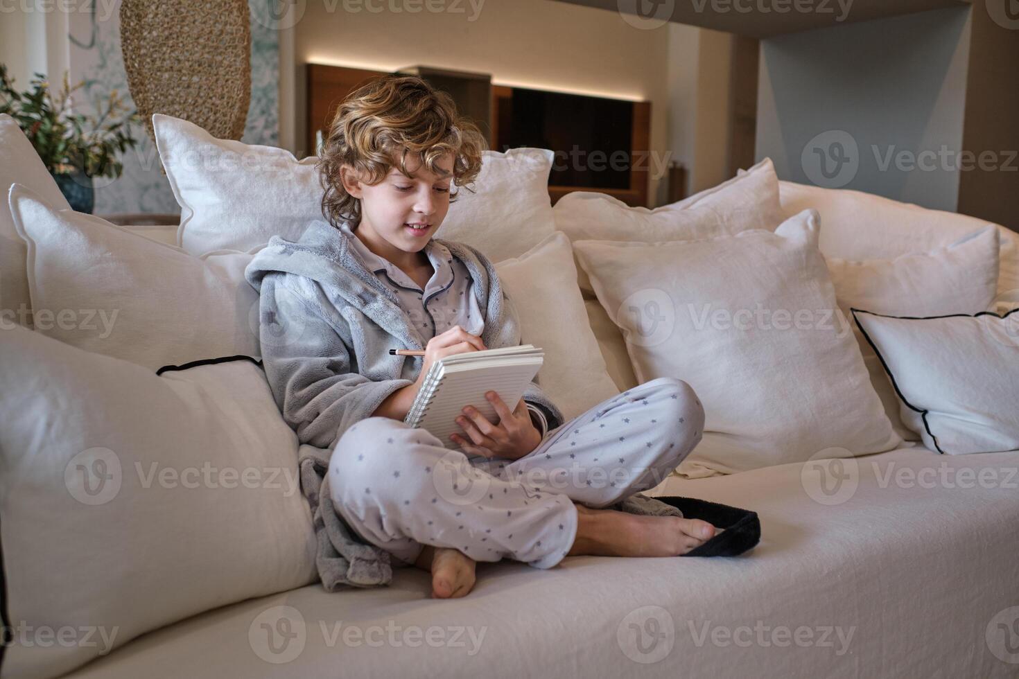 Enthusiastic preteen boy drawing sketch with pencil photo