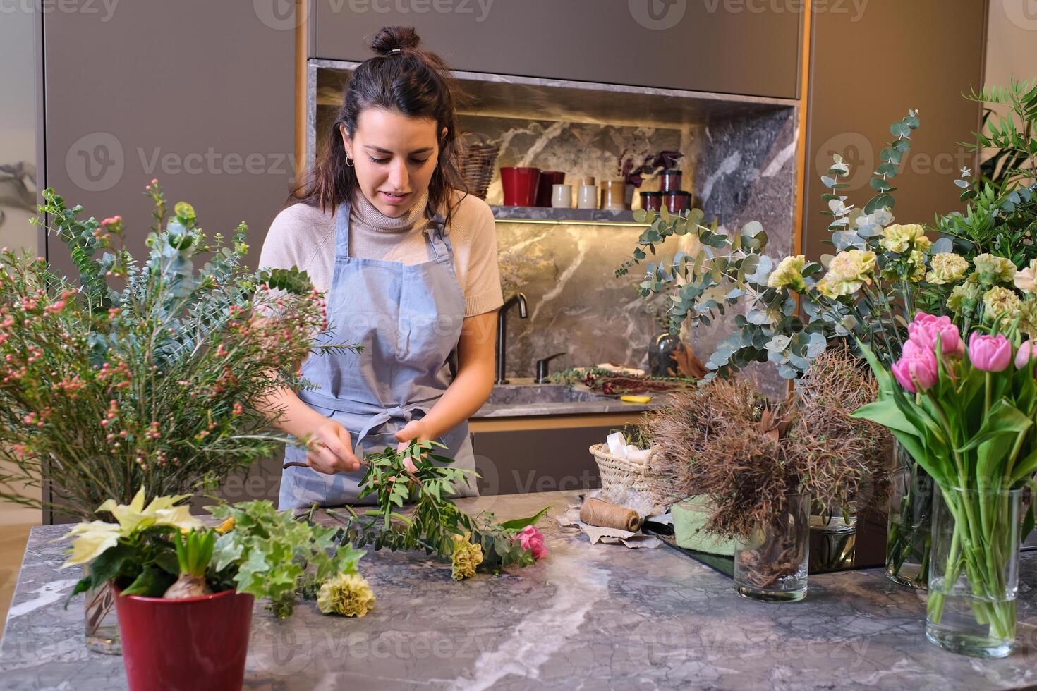 Female florist in apron cutting flowers photo