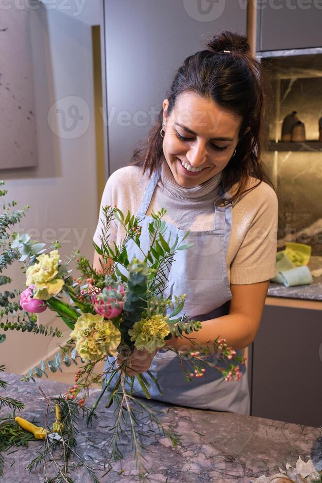 Happy female florist composing bouquet photo