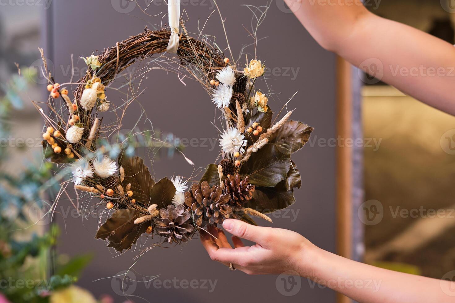 Faceless florist with withered handmade wreath in store photo