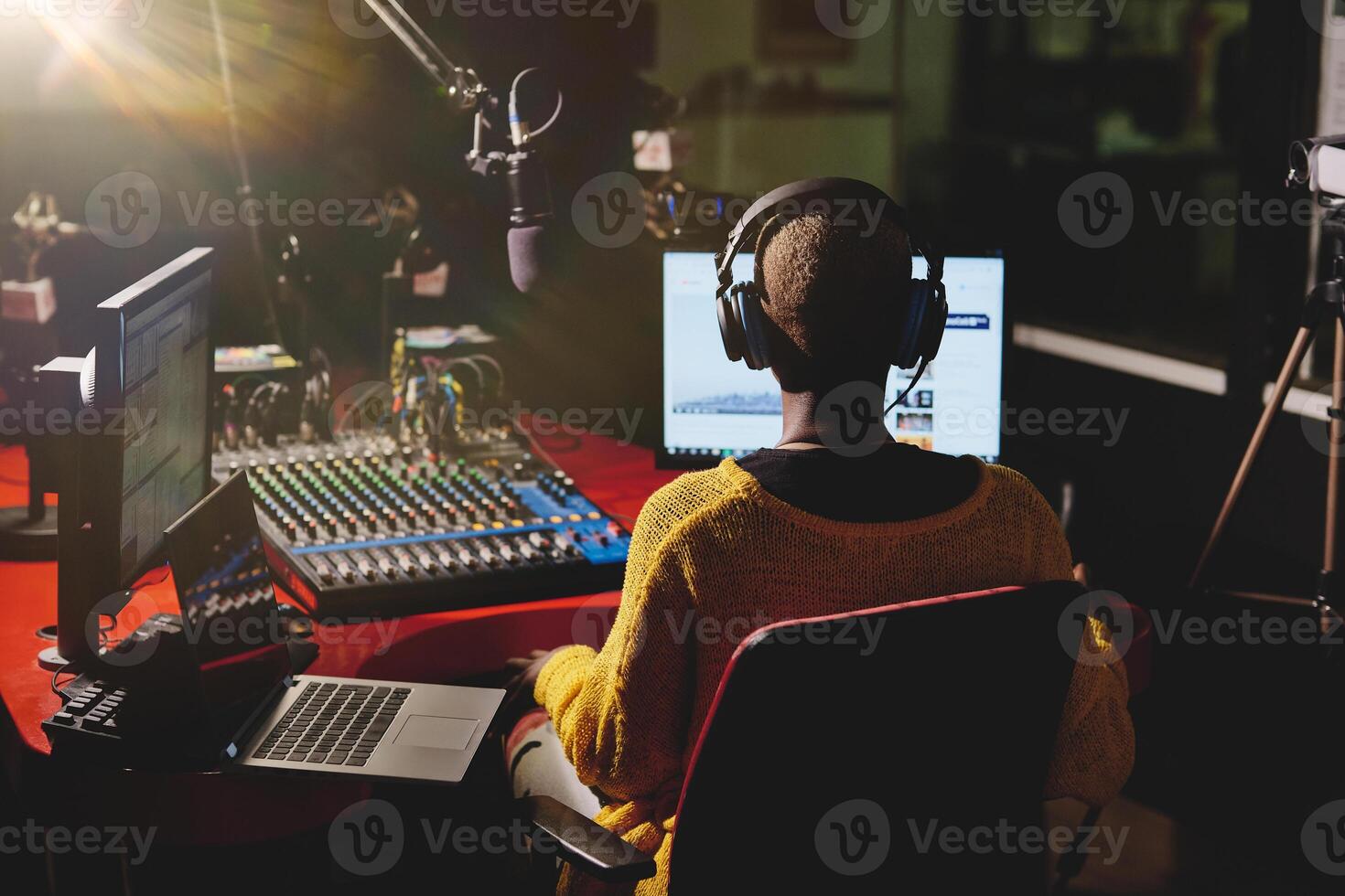 Black female broadcaster in dark radio studio photo