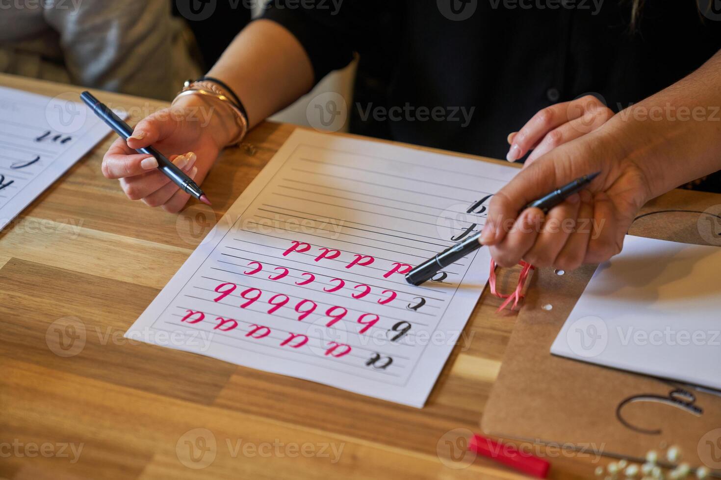 Crop teacher showing student how to write letters photo