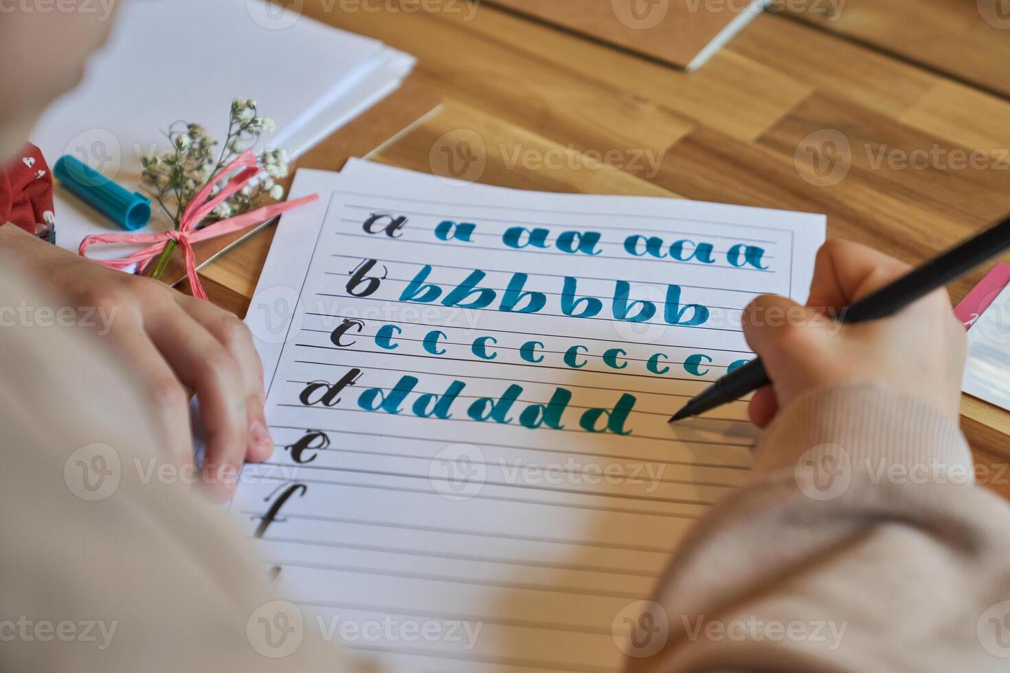 Crop person drawing letters on paper sheet photo