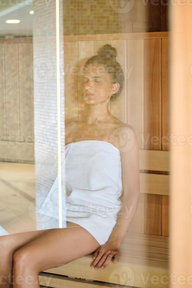 Female sitting in sauna in spa center photo